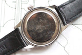 Close-up of a vintage pilot watch case back with scratches and black leather strap