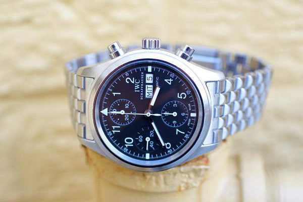Stainless steel pilot chronograph watch with black dial and metal bracelet on display
