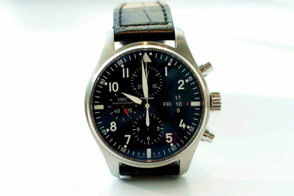 Stainless steel chronograph pilot watch with black dial and leather strap on white background