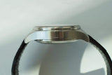 Side view of stainless steel chronograph watch case with black leather strap
