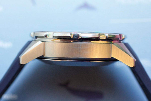 Side view of a luxury Swiss-made chronograph watch with brushed metal case and black strap