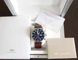 Blue dial chronograph watch with brown leather strap in box, includes warranty and manuals