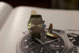 Back view of IWC Pilot Chronograph watch with bullets on watch magazine background