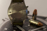 IWC Pilot Chronograph 3706 watch caseback displayed on dial face, with bullets nearby