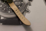Close-up of a luxury chronograph watch with black dial and tan leather strap