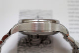Side profile of a stainless steel luxury watch case with metal bracelet, close-up view