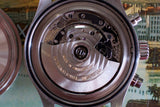 Close-up of Swiss automatic chronograph watch movement with visible rotor and gears
