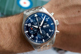 Stainless steel chronograph watch with blue dial and day-date display on wrist