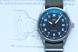 IWC Schaffhausen Spitfire Automatic luxury watch with a dark blue dial and fabric strap.
