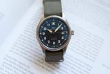IWC Spitfire Automatic luxury watch with a black dial and olive green textile strap