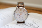 Luxury IWC Portofino 8 Days watch with brown leather strap on open book