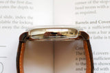 Side view of a luxury watch with brown leather strap and polished case