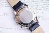 Case back of an International Watch Co. luxury watch with a beige and blue leather strap.
