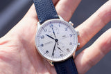 Close-up of an IWC Schaffhausen chronograph automatic watch with a white dial and blue leather strap.