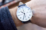 Close-up of an IWC Schaffhausen automatic chronograph watch with a white dial on a wrist.