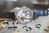 Swiss hand-wound luxury watch with visible movement and black leather strap