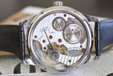 Close-up of mechanical Swiss watch caseback, showcasing intricate luxury movement details.