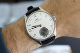 IWC Portuguese hand-wound luxury Swiss watch with black leather strap on wrist