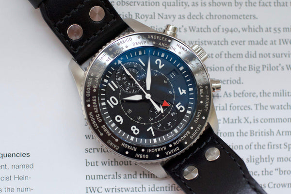 Luxury chronograph pilot watch with black dial, world time bezel, and leather strap