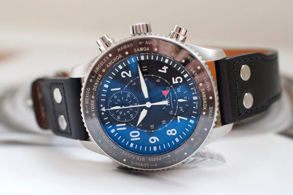 Luxury chronograph watch with blue dial, time zone bezel, and black leather strap