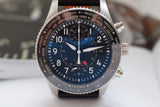 Luxury Swiss chronograph watch with blue dial, world time bezel, and black leather strap