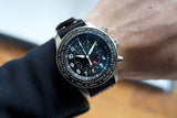 Luxury Swiss chronograph watch with black dial and city bezel on wrist