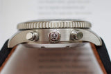 Close-up side view of a stainless steel chronograph watch with textured bezel and pushers