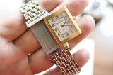 Close-up of a Jaeger-LeCoultre Reverso luxury watch with a two-tone gold and steel bracelet.
