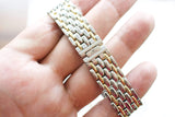 Close-up of a two-tone stainless steel and gold luxury watch bracelet with JL logo.