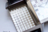 Close-up of luxury Swiss reversible watch with silver guilloché case and white dial