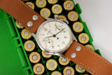 Lemania mono pusher chronograph watch with brown leather strap on cartridge case