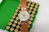 Vintage Lemania mono-pusher chronograph watch with brown leather strap on box of brass cartridges