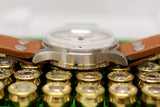Luxury vintage chronograph watch with brown leather strap, side view on brass casings