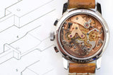 Close-up of a luxury Swiss watch with an open case back showing the internal movement mechanisms.
