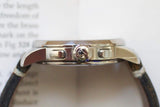 Side view of a luxury silver watch with a leather strap and crown detail.