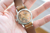 Close-up of a luxury Swiss watch with a transparent case back showing the automatic movement.