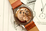 Rear view of a luxury Omega Swiss-made watch showing the internal mechanical movement.