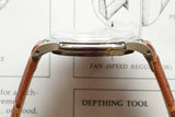 Side profile view of a luxury watch with a brown leather strap.