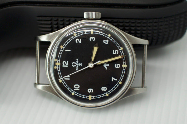 Vintage Omega Fat Arrow watch with black dial, Arabic numerals, and silver case