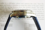 Close-up side view of a luxury Swiss watch with blue strap and brushed metal case