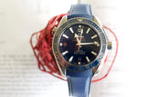 Blue luxury dive watch with rotating bezel and rubber strap, displayed against a light background