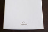 White Omega watch box with Omega logo on a dark surface