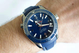 Blue dial luxury dive watch with rotating bezel on wrist, stainless steel case, sporty design