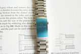 Close-up of Omega Seamaster Liquidmetal stainless steel watch bracelet on technical book