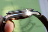 Side profile view of a luxury Swiss watch with a leather strap and polished steel case.