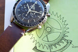 Close-up of a vintage Omega Speedmaster Professional luxury watch on a brown leather strap.