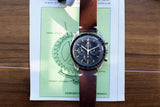 Omega Speedmaster Professional luxury watch with brown leather strap on technical diagram.