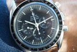 Close-up of a vintage Omega Speedmaster Professional luxury chronograph watch with a black dial.