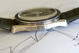 Close-up side view of vintage Swiss luxury watch with fabric strap on technical drawing