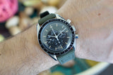 Omega Speedmaster vintage chronograph watch with black dial and green strap on wrist